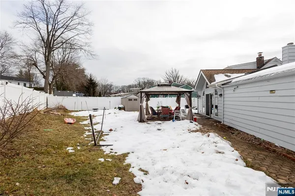 a view of the house with a yard covered in snow
