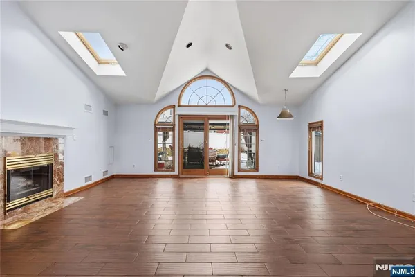 an empty room with floor fireplace and windows