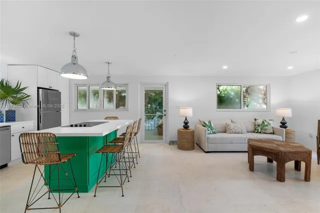 a living room with furniture a dining table and a chandelier