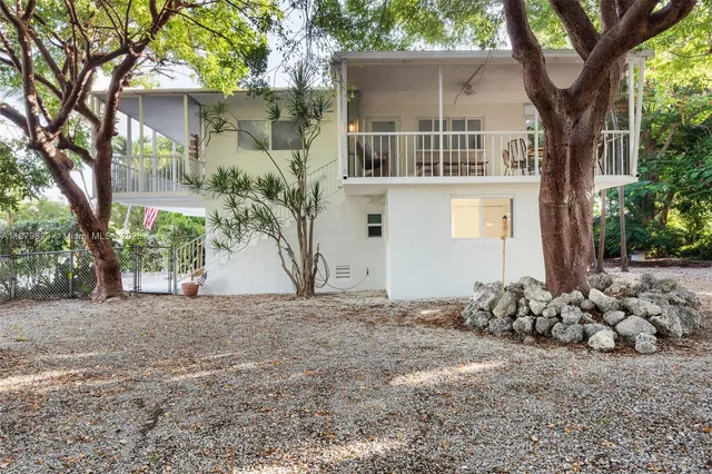 a front view of a house with a tree
