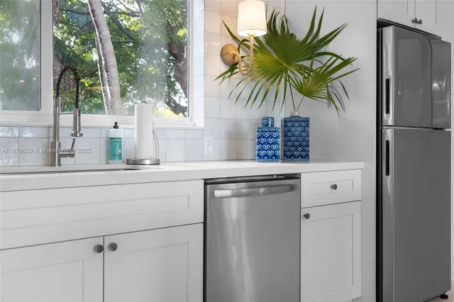 a kitchen with a refrigerator and a potted plant