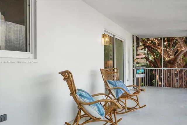 a view of a room with furniture and large windows