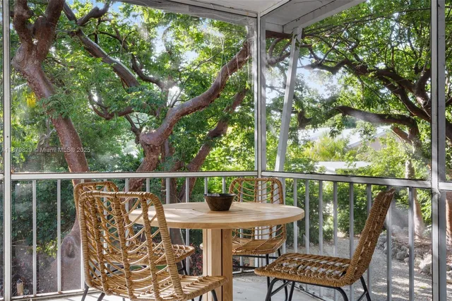 a balcony with wooden floor table and chairs