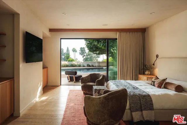 a bedroom with a bed and large windows