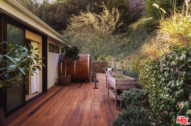 a backyard of a house with wooden floor and outdoor seating