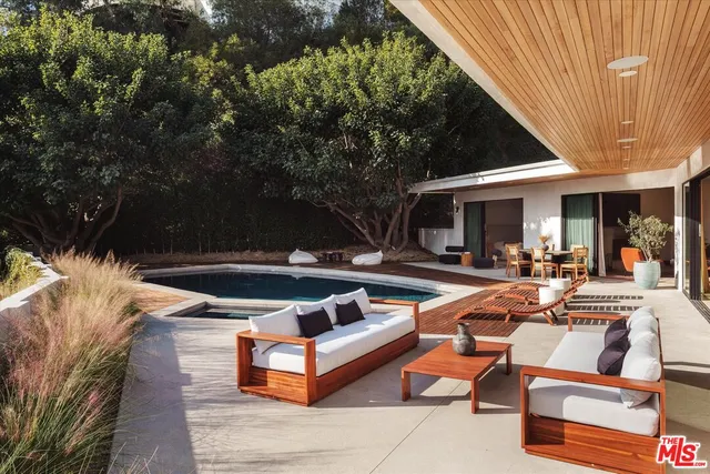 a view of backyard with swimming pool and outdoor seating
