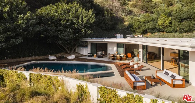 a view of a house with pool and chairs