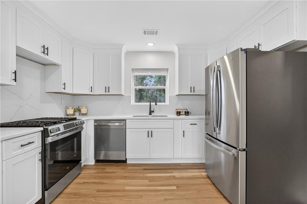 2967 Flat Shoals Road Decatur, GA 30034 - Photo 9 of 37 a kitchen with stainless steel appliances a refrigerator sink and stove