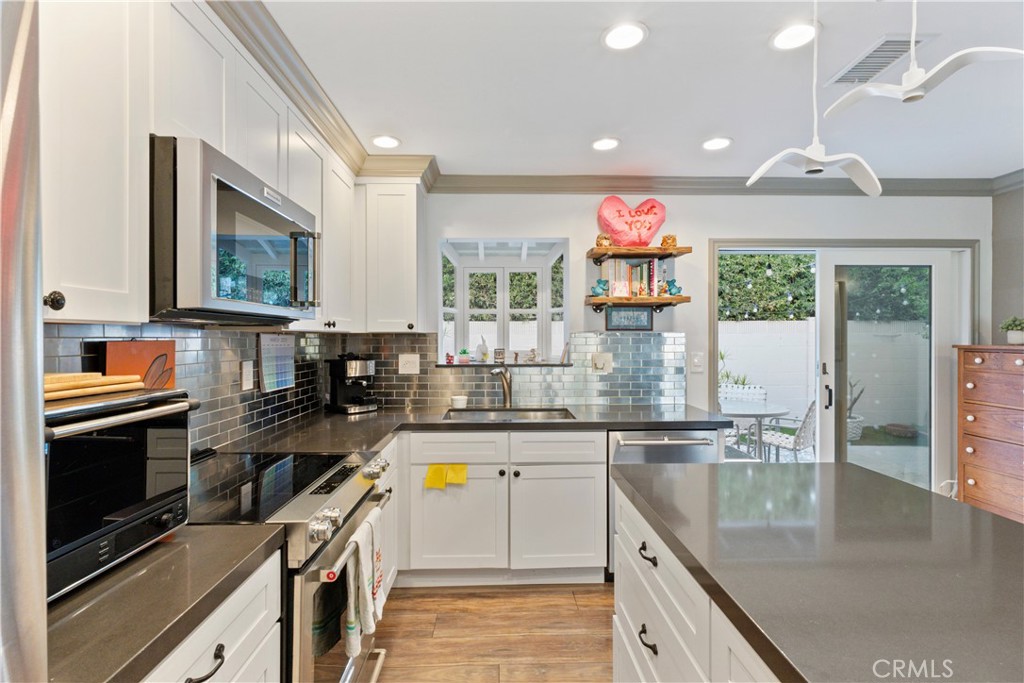 419 Gloucester Drive Costa Mesa, CA 92627 - Photo 11 of 51 a kitchen with stainless steel appliances granite countertop a stove a sink and a microwave