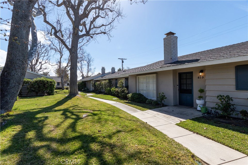 419 Gloucester Drive Costa Mesa, CA 92627 - Photo 44 of 51 a front view of a house with a garden and yard