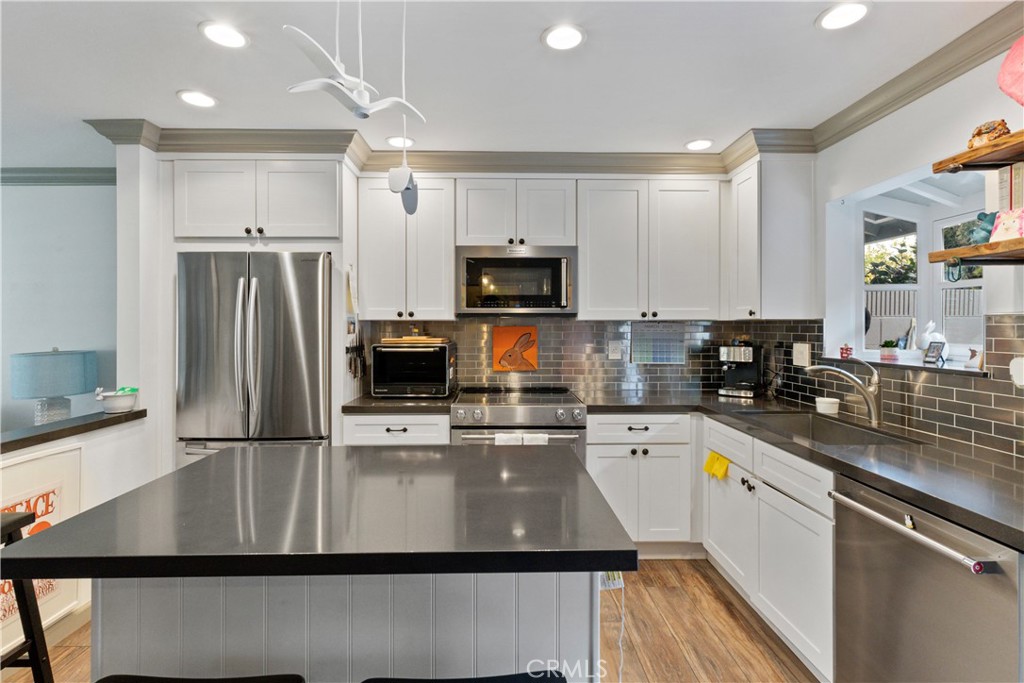 419 Gloucester Drive Costa Mesa, CA 92627 - Photo 8 of 51 a kitchen with kitchen island a counter top space cabinets and stainless steel appliances
