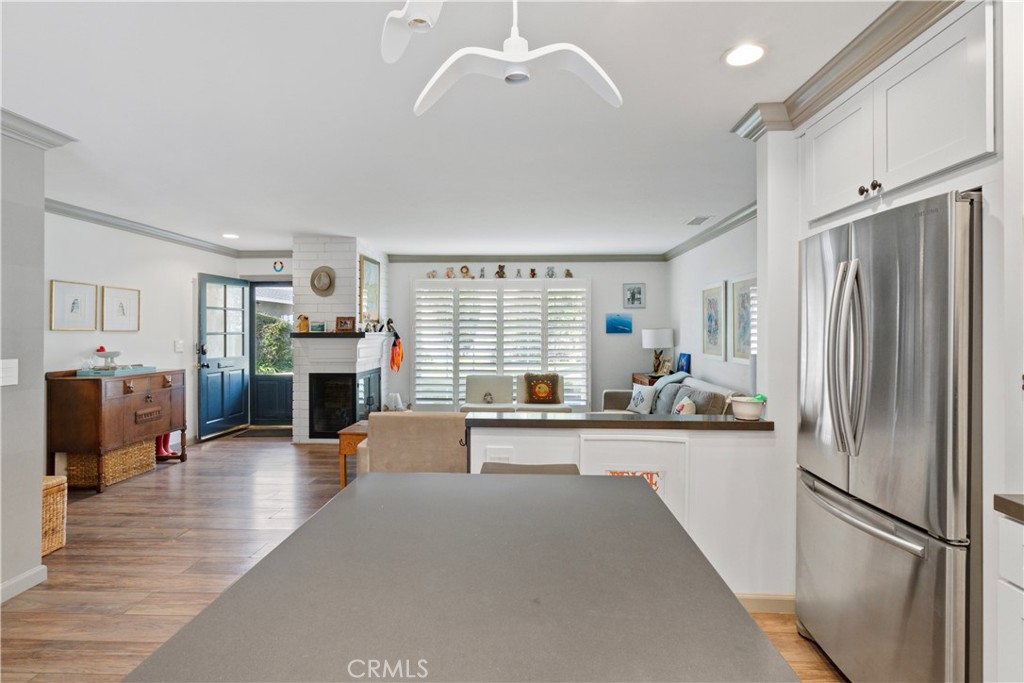 419 Gloucester Drive Costa Mesa, CA 92627 - Photo 10 of 51 a large open kitchen with stainless steel appliances granite countertop a refrigerator oven a sink dishwasher and a fireplace with wooden floor