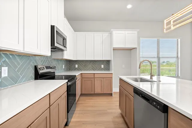 a kitchen with a sink stove and cabinets
