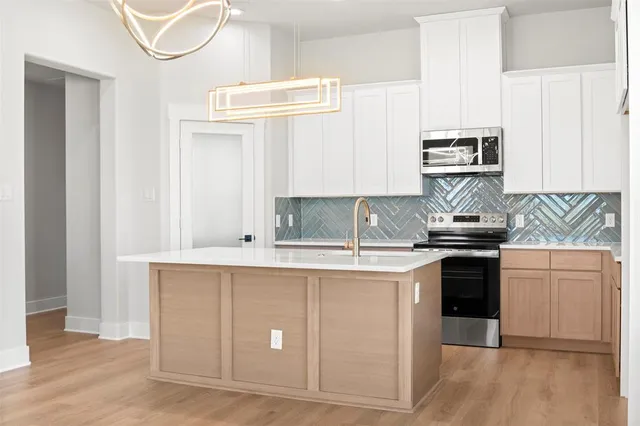 a kitchen with stainless steel appliances granite countertop a sink and a stove
