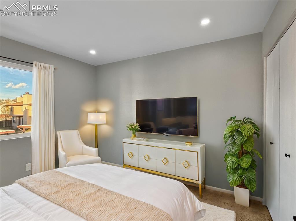 3033 Starlight Circle Colorado Springs, CO 80916 - Photo 28 of 44 a bedroom with a bed and a flat screen tv