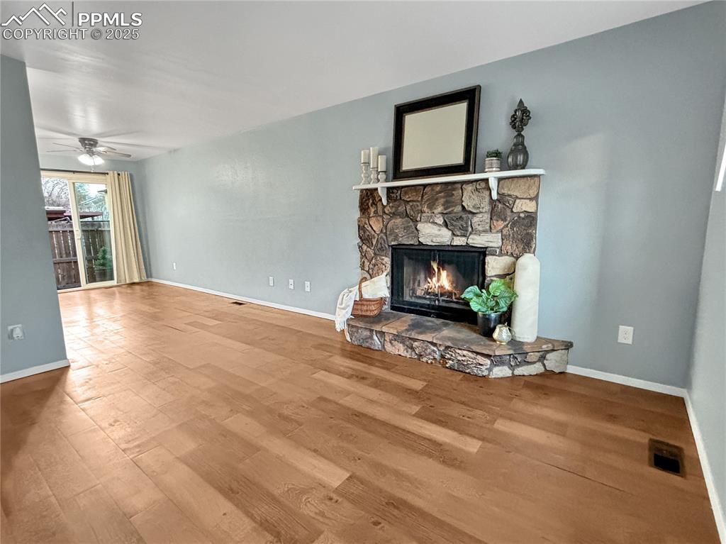 3033 Starlight Circle Colorado Springs, CO 80916 - Photo 3 of 44 a view of an empty room with wooden floor fireplace and a window