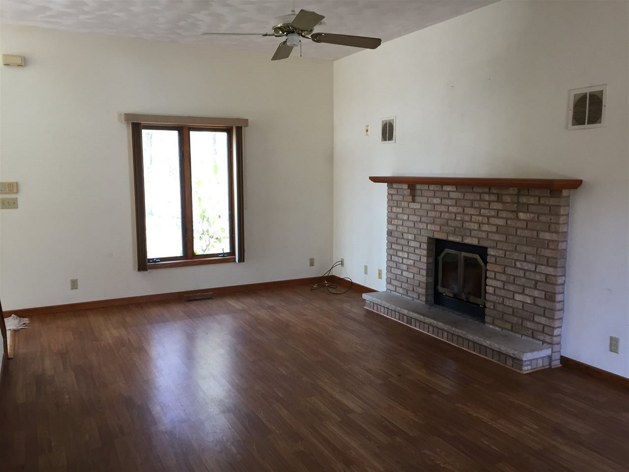 3275 North Meridian Road Stillman Valley, IL 61084 - Photo 9 of 24 an empty room with wooden floor a fireplace and windows