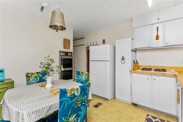 a dining room with stainless steel appliances a refrigerator and a table
