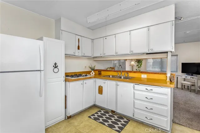 a kitchen with stainless steel appliances granite countertop a refrigerator sink and white cabinets