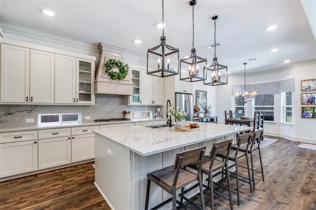 a kitchen with granite countertop a sink a stove and cabinets