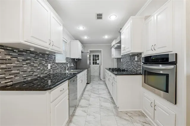 a kitchen with stainless steel appliances granite countertop a sink and cabinets