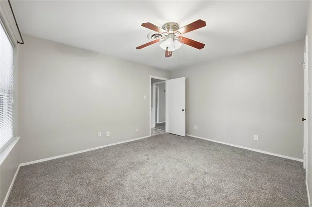an empty room with closet and ceiling fan