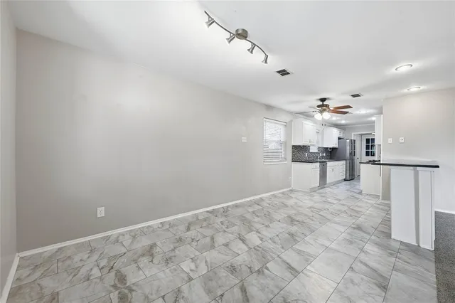 a view of a kitchen with refrigerator and chairs