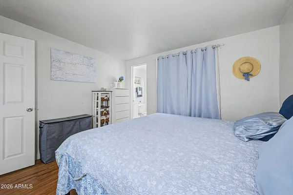 a bedroom with a bed and a wooden floor