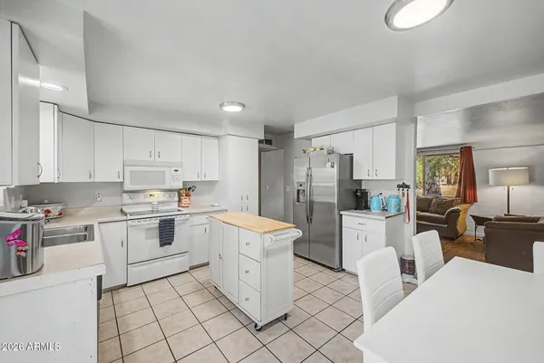 a kitchen that has a refrigerator and table in it