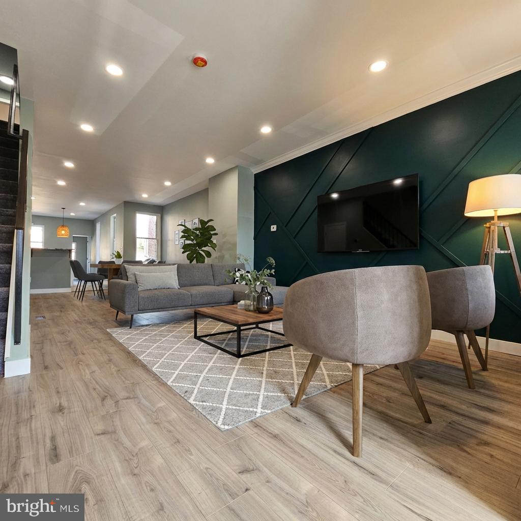 a living room with furniture a rug and kitchen view