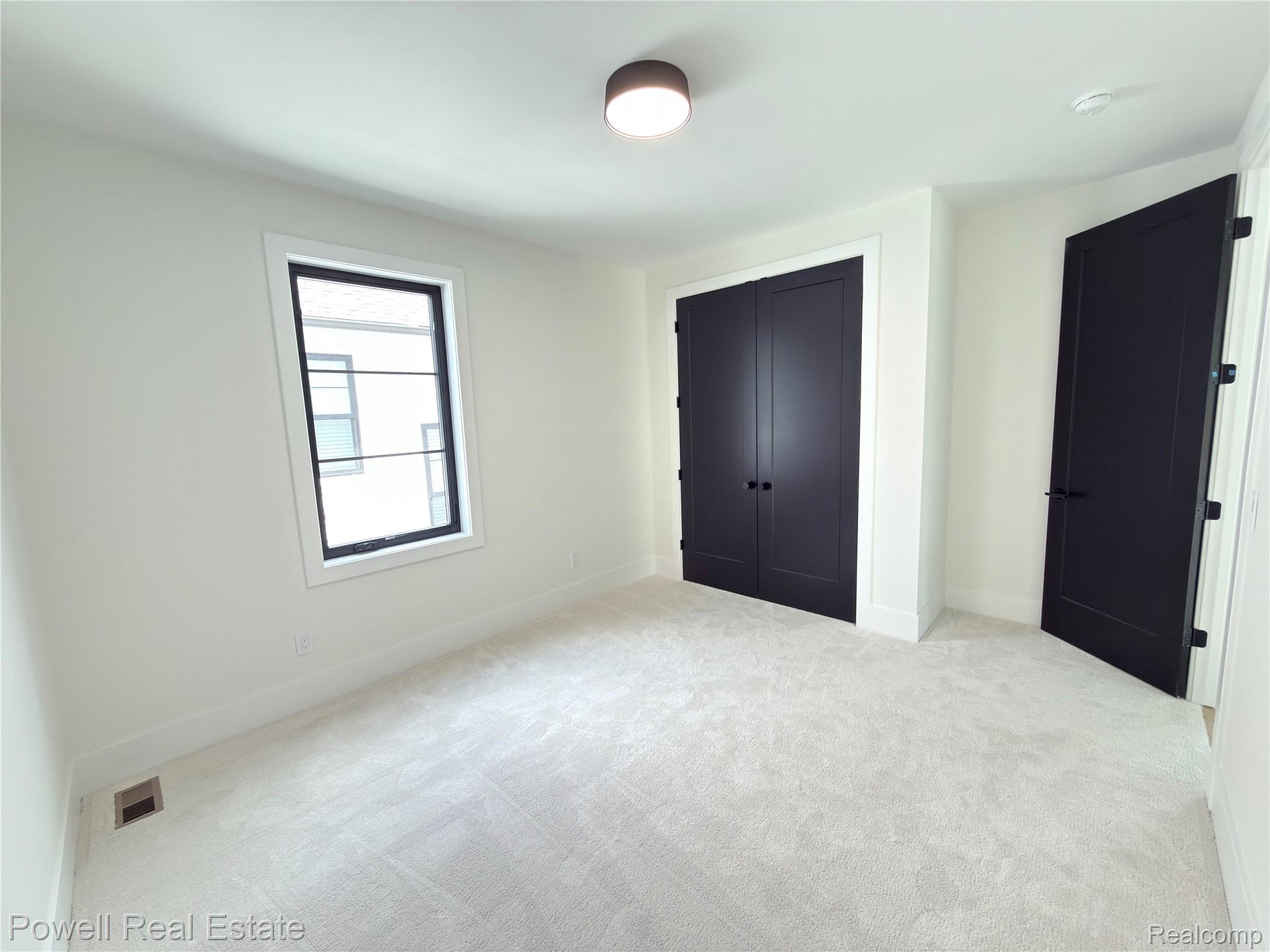 1998 Hazel Street Birmingham, MI 48009 - Photo 17 of 22 Light-toned carpeting complements white walls and trim in this room featuring a window with dark framing and a flush-mount ceiling light