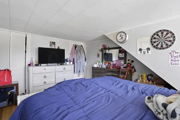 a bed room with a bed a television and a mirror