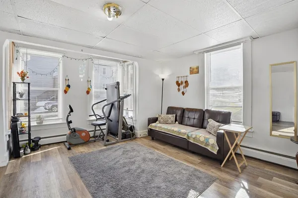 a living room with furniture gym equipment and a large window