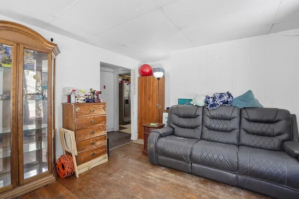 a living room with furniture a refrigerator and a flat screen tv