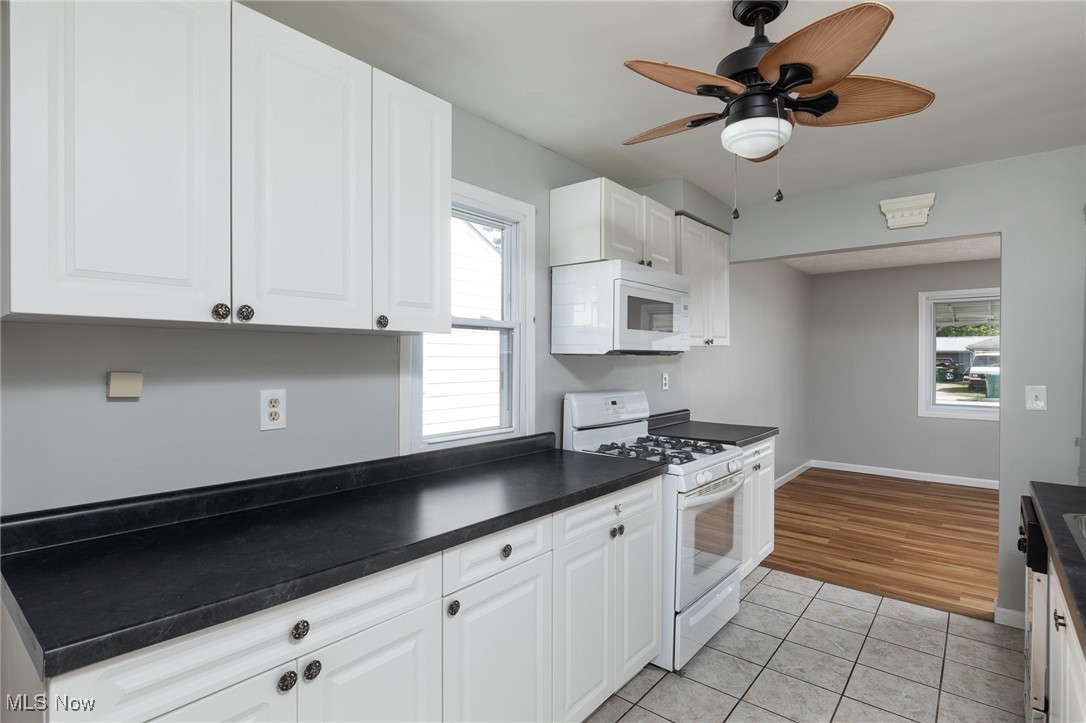 4782 Belle Meadow Road Mentor, OH 44060 - Photo 11 of 22 Kitchen featuring white appliances, white cabinetry, ceiling fan, and light hardwood / wood-style flooring