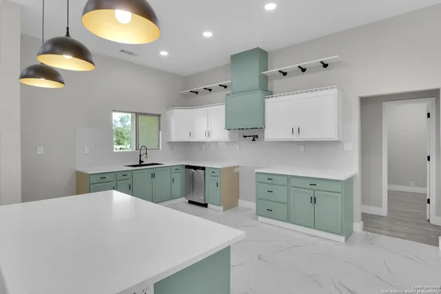 a kitchen with a sink cabinets and wooden floor