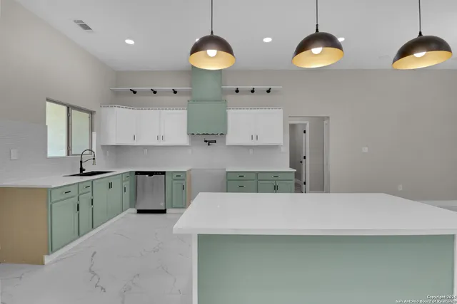 a kitchen with a sink cabinets and wooden floor