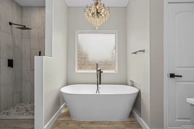 a white bath tub sitting in a bathroom next to a window
