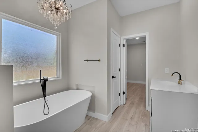 a bathroom with a tub a sink and mirror