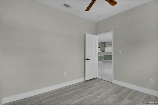 an empty room with closet and a ceiling fan