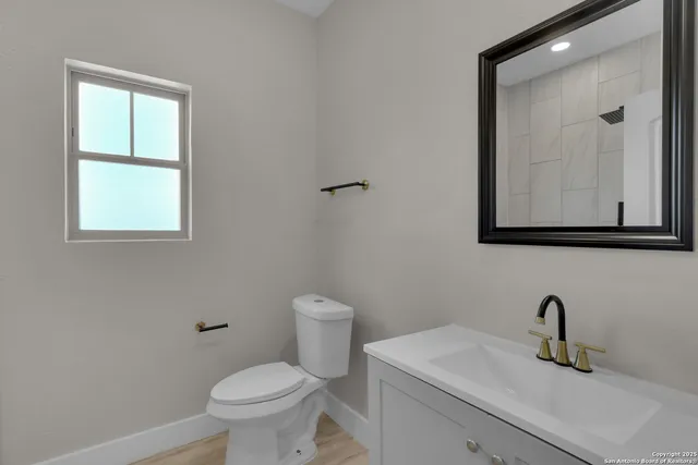 a bathroom with a toilet sink and mirror