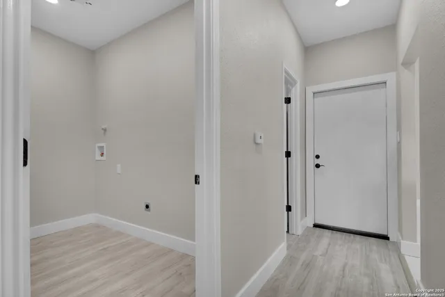 a view of a hallway with wooden floor