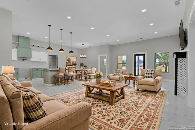 a living room with furniture and a view of kitchen