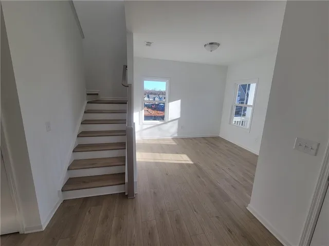 a view of entryway and hall with wooden floor