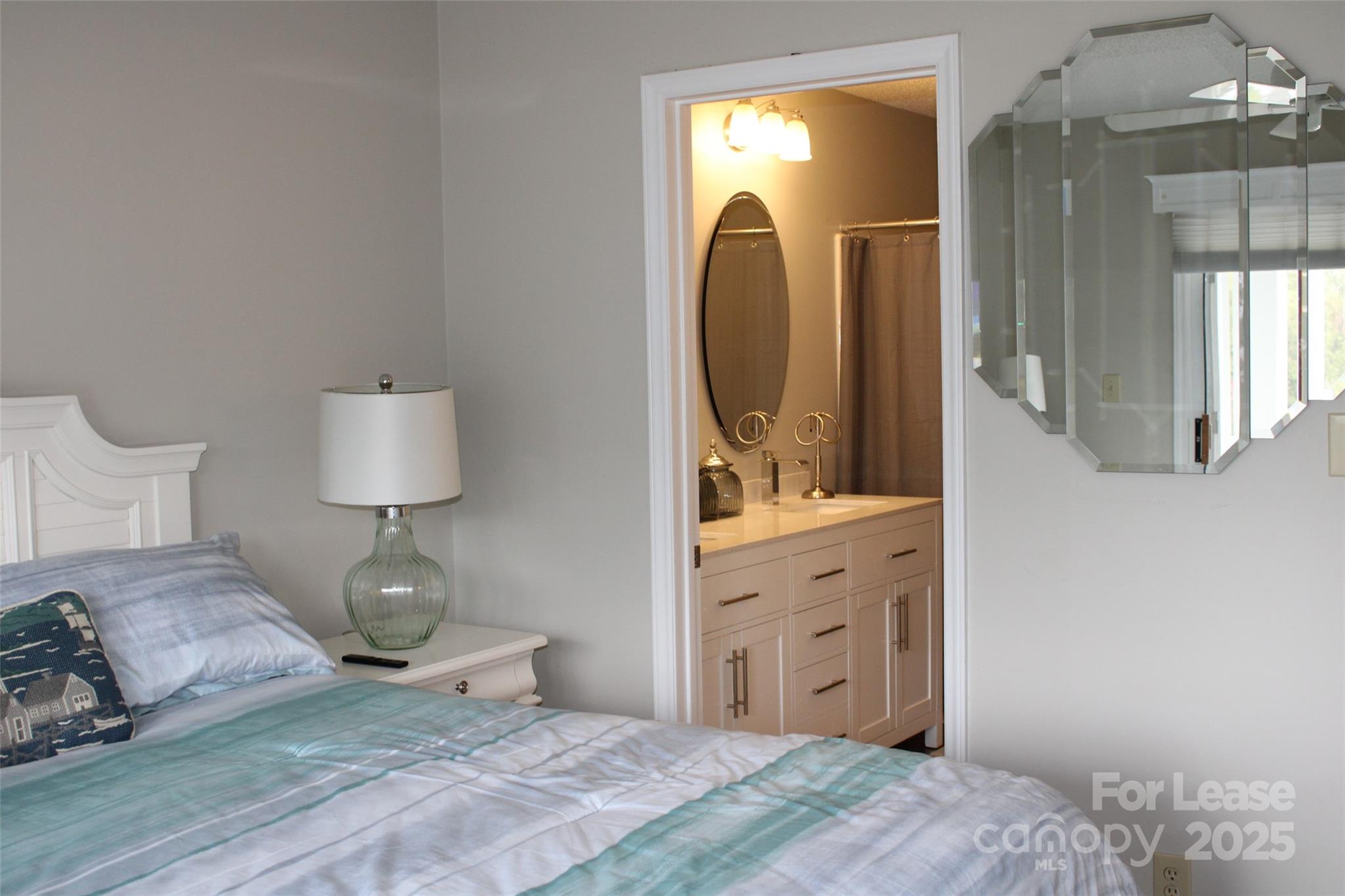 17919 Kings Point Drive, Unit E Cornelius, NC 28031 - Photo 18 of 30 a spacious bedroom with a bed and a mirror