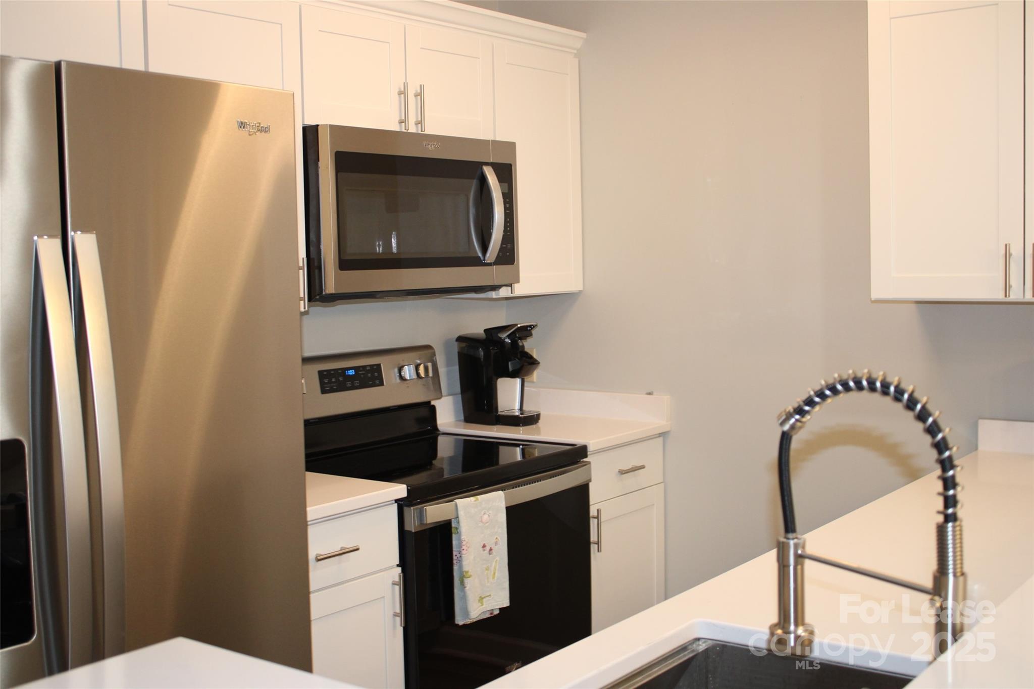 17919 Kings Point Drive, Unit E Cornelius, NC 28031 - Photo 2 of 30 a kitchen with a refrigerator stove and microwave