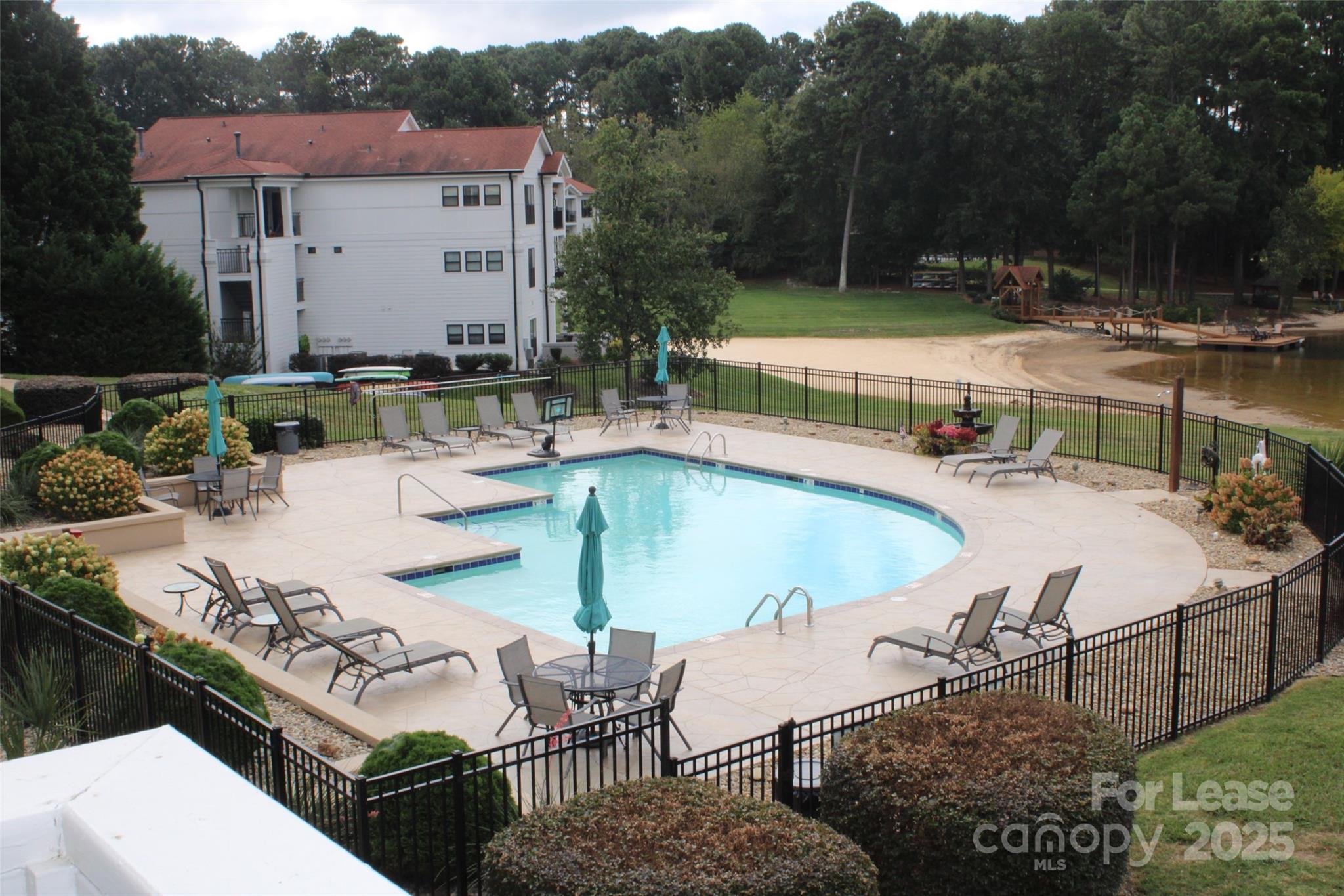 17919 Kings Point Drive, Unit E Cornelius, NC 28031 - Photo 24 of 30 a view of a patio with couches table and chairs with potted plants and large trees