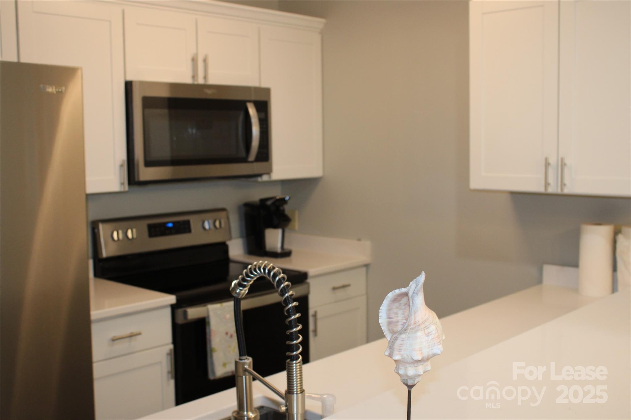 17919 Kings Point Drive, Unit E Cornelius, NC 28031 - Photo 3 of 30 a kitchen with a stove and a microwave