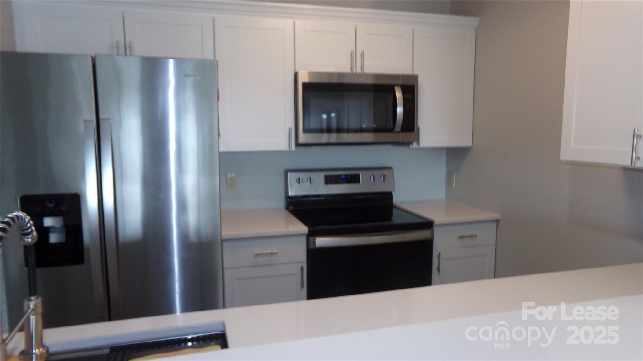17919 Kings Point Drive, Unit E Cornelius, NC 28031 - Photo 4 of 30 a kitchen with stainless steel appliances granite countertop a refrigerator stove and microwave