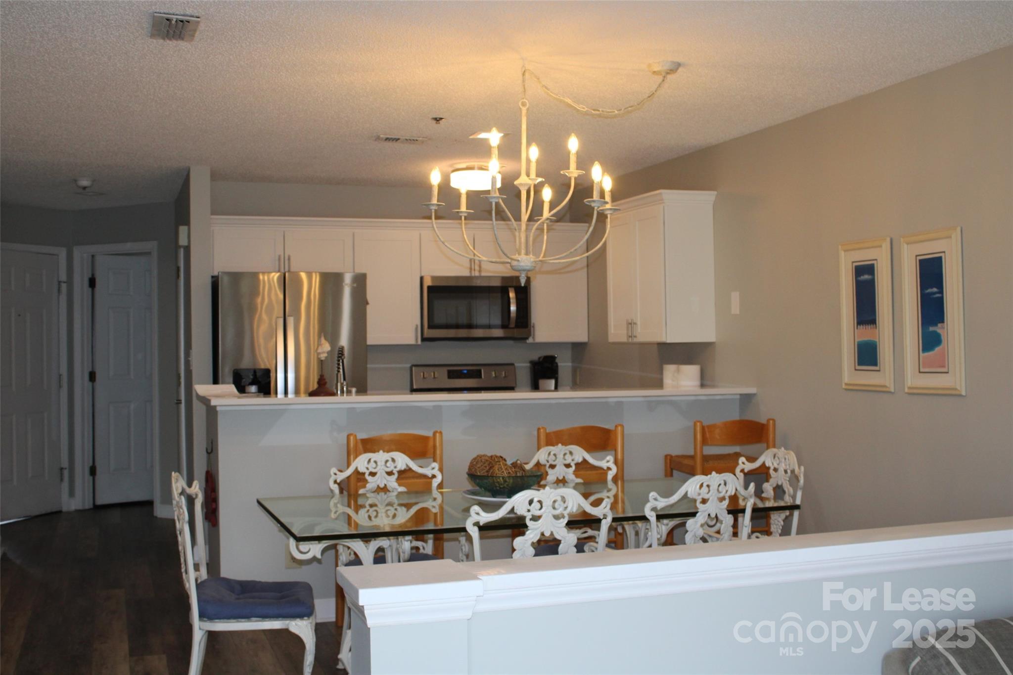 17919 Kings Point Drive, Unit E Cornelius, NC 28031 - Photo 10 of 30 a kitchen with stainless steel appliances granite countertop a refrigerator and a stove top oven